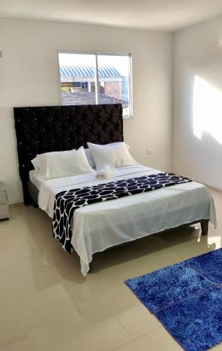 巴兰基亚Hostal De la 8的一间卧室配有一张蓝色地毯的大床