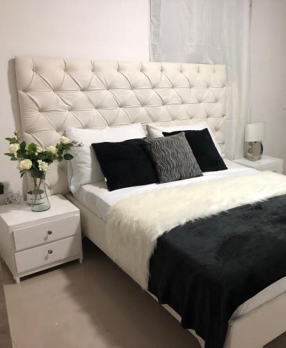 巴兰基亚Hostal De la 8的卧室配有一张带黑色枕头的大型白色床。