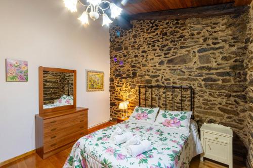 DoadeCasa Ruperto的一间卧室设有一张床和石墙