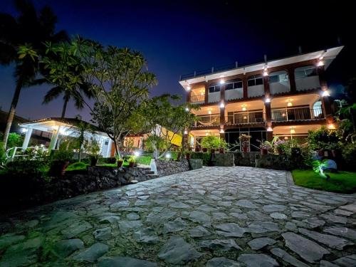 锡瓦塔塔内霍Hotel Villas Ema的一家晚上在前面有石头路的酒店