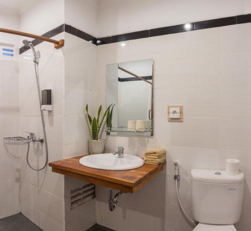 沙努尔Sanur Lodge的一间带水槽、卫生间和镜子的浴室