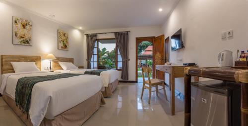 沙努尔Sanur Lodge的酒店客房配有两张床和一张书桌