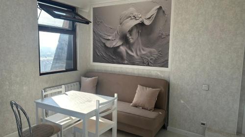 比什凯克Best view in city, secured 24/7的客厅配有桌子、沙发、桌子和绘画作品