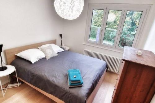 日内瓦Maison du Jonc, Genève-Aéroport的睡在卧室床上的蓝色袋子