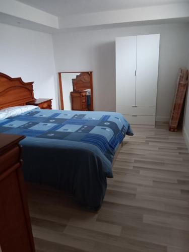 AloveraApartamento Triana的一间卧室配有一张带蓝色棉被的床