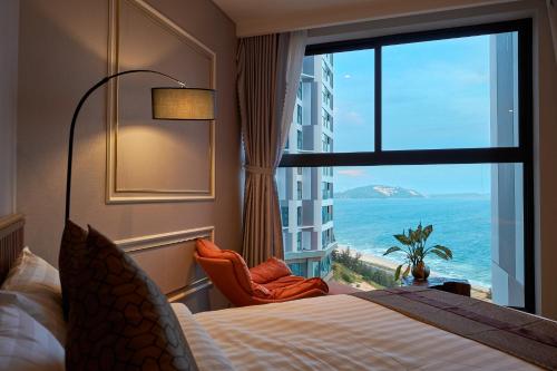 Ấp Long SơnApec Mandala Wyndham Mui Ne Ngoc Linh的酒店客房设有一张床和一个享有海景的窗户。