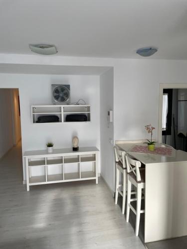ArguineguínPURA VIDA的白色的厨房配有柜台和桌子