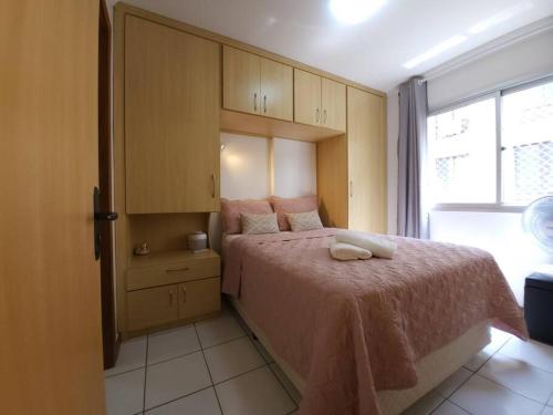 巴西利亚Sweet Home Sudoeste - Completo e aconchegante的一间卧室配有一张带粉色毯子的床和窗户。