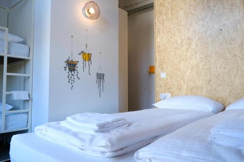 兹沃勒Hostel & Bar De Basis的一间卧室配有两张带白色床单的床