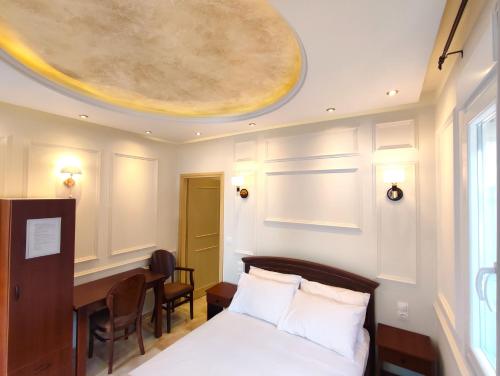沃洛斯Villa Miltiadis GreeceFilloxenia的一间卧室设有一张床、一张桌子和天花板