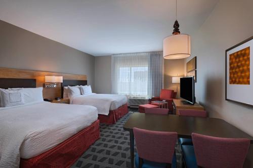 欧文TownePlace Suites by Marriott Dallas DFW Airport North/Irving的酒店客房带两张床和一张桌子以及椅子。