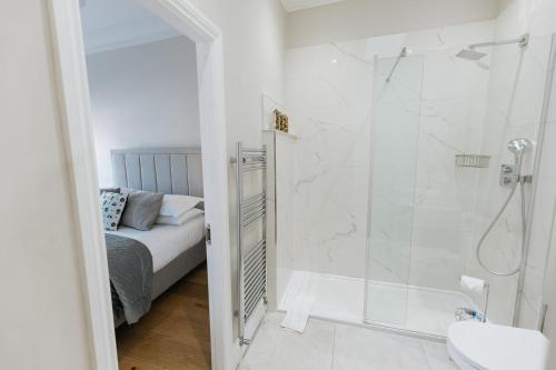 里士满SWALEDALE, OLD SCHOOL ROOMS - Luxury Apartment in Richmond, North Yorkshire的带淋浴的白色浴室和1张床