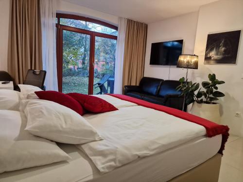 布莱德Aparthotel Gaja的一间卧室配有一张带红色和白色枕头的大床