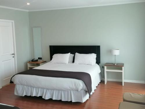 孔斯蒂图西翁德尔里奥酒店的一间卧室配有一张大床和黑色床头板