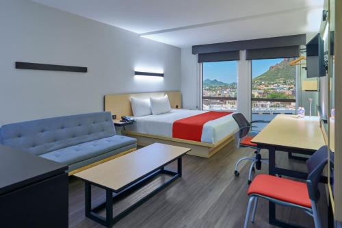 瓜伊马斯City Express by Marriott Guaymas的酒店客房配有床、沙发和桌子。