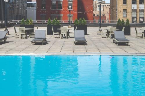 哥伦布哥伦布市中心万丽酒店的一个带桌椅和桌椅的游泳池