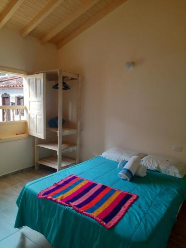 巴里查拉Habitación con baño privado的一间卧室配有一张带彩色毯子的床