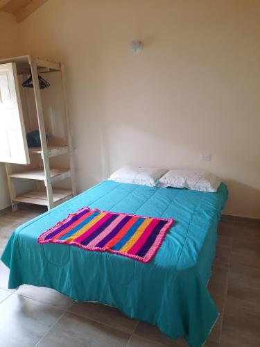 巴里查拉Habitación con baño privado的床上有五颜六色的毯子