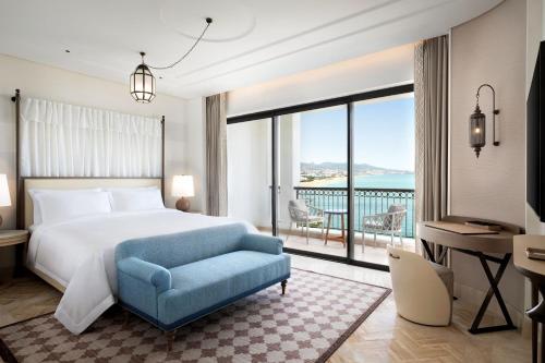 弗尼迪克The St. Regis La Bahia Blanca Resort - Tamuda Bay的一间卧室配有一张床、一张书桌和一个大窗户