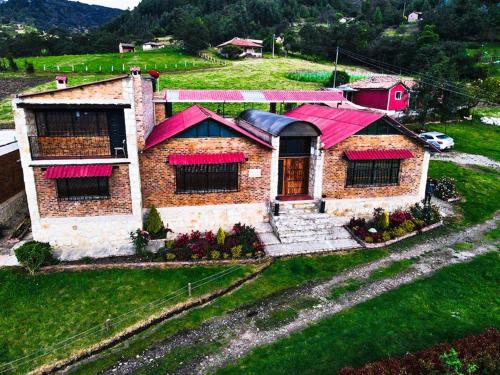 蒙圭Brisas de San Roque by Rotamundos的绿色田野上红色屋顶的房子