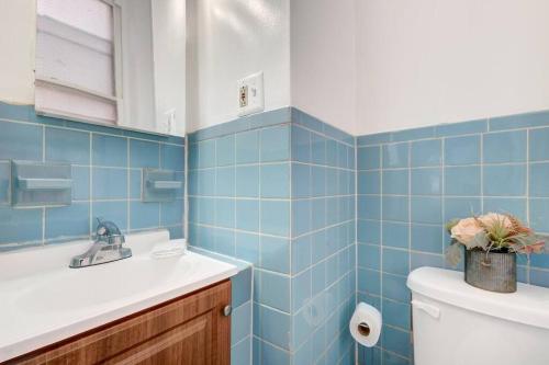 费城Timeless Experience Lovely Spacious 1 Bdrm Apt的蓝色瓷砖浴室设有水槽和卫生间