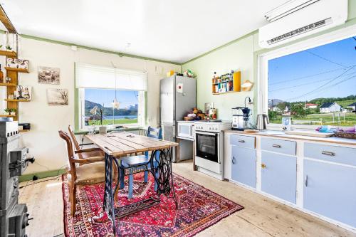 KvaløyaStorjord Farmstay Ranchhouse的厨房配有木桌和桌子