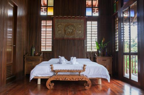 怡保Arundina的一间卧室配有一张带长凳和窗户的床。