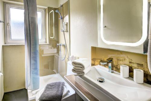 萨尔茨堡霍夫曼酒店的一间带水槽、淋浴和镜子的浴室