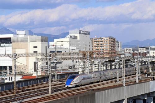 高崎高崎大都会酒店的城市中拥有建筑物的轨道上的火车