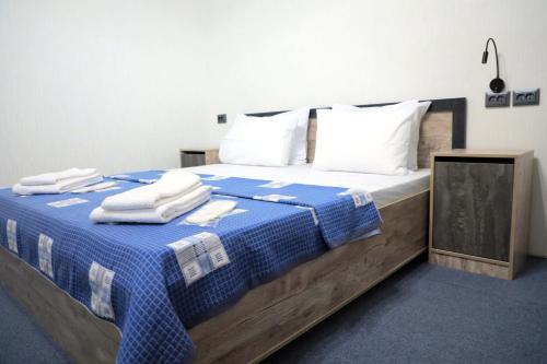塔什干SAFAR hotel的卧室配有蓝色和白色的床,提供毛巾