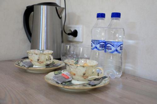 塔什干SAFAR hotel的2瓶水和2杯桌子上的水