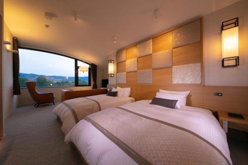 京都Riverte Kyoto Kamogawa的酒店客房设有两张床和窗户。
