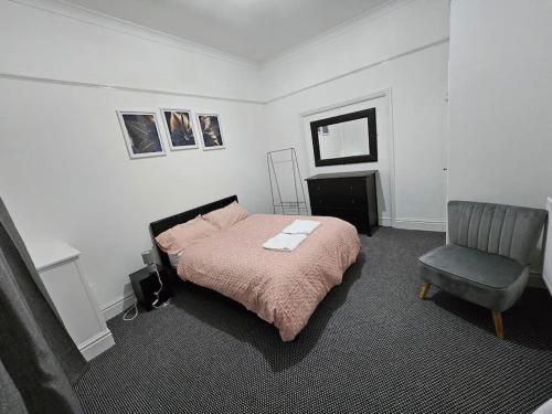 普雷斯顿Cheerful Home near Preston train station & Uclan的一间卧室配有一张床和一把椅子