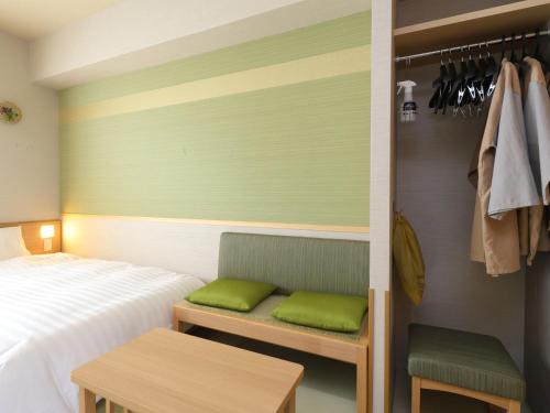 别府Beppu Hatto Onyado Nono Beppu的一间卧室配有床和带绿色枕头的长凳