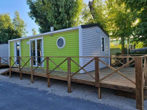 坎佩略Camping Costa Blanca的木制甲板上的一个绿色和白色的小房子