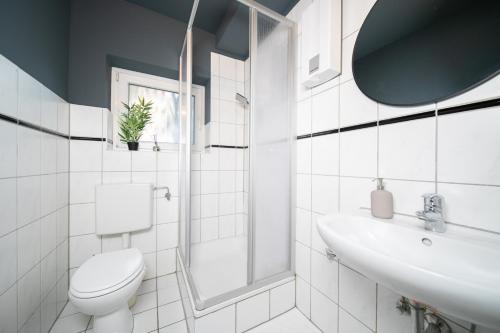 诺伊斯Favorite Stays - Suite and More - Westfeld的白色的浴室设有卫生间和水槽。