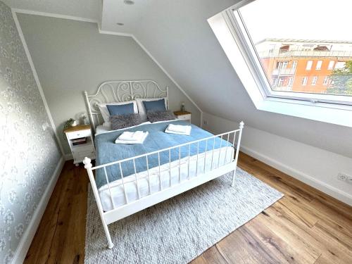 爱尔福特Customflats Erfurt - Tiefgarage - frisch renoviert的一间卧室配有一张带蓝色床单的床和一扇窗户。