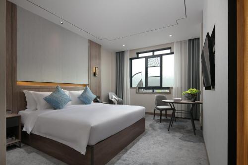 张家界张家界专家村阳光庭院酒店的卧室配有一张白色的大床和一张桌子