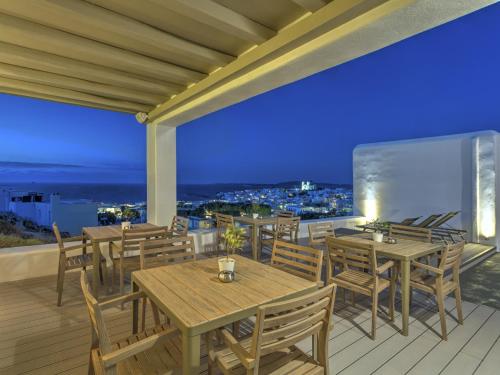 纳乌萨帕帕达克斯酒店的晚上在阳台上设有桌椅的餐厅