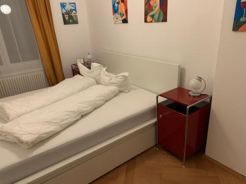 赫拉德茨 - 克拉洛韦Apartment Grossman的一张铺有白色床单和红色床头柜的床