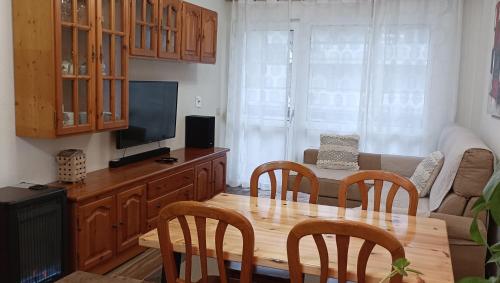 圣维森特-德拉巴尔克拉Apartamento a 30 metros de la playa的客厅配有木桌和电视。