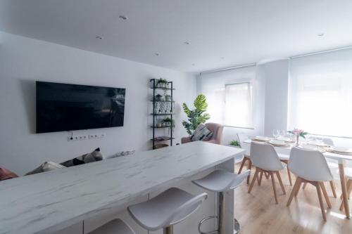 希洪Lujoso apartamento entre 2 playas con garaje, wifi的客厅配有一张白色的大桌子和椅子
