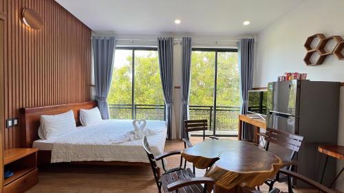 富国Nhu Huose Phu Quoc的卧室配有一张床和一张桌子及椅子
