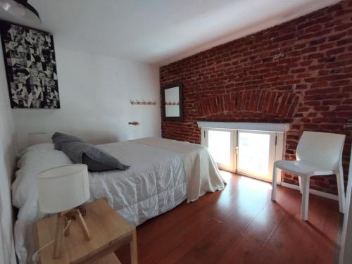 蒙得维的亚Zabalita, hermoso y cálido loft en la Ciudad Vieja的一间卧室设有一张床和砖墙