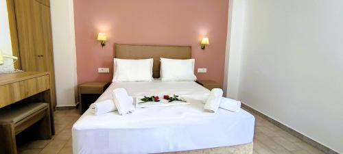 蒂锡利维拉吉亚斯一室公寓的酒店客房的白色床上摆放着鲜花