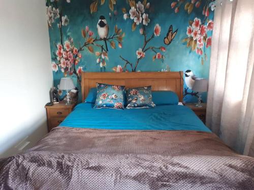 巴洛赫Cosy 2 bedroom house on the edge of Balloch的卧室配有蓝色的床,墙上有鸟儿