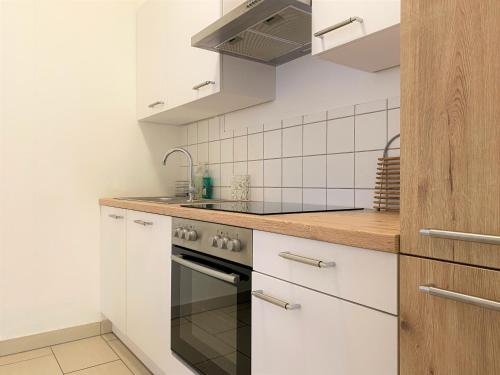 维也纳新城Stadtsuite mit Sauna in Wiener Neustadt 135 m2的厨房配有白色橱柜和炉灶烤箱。