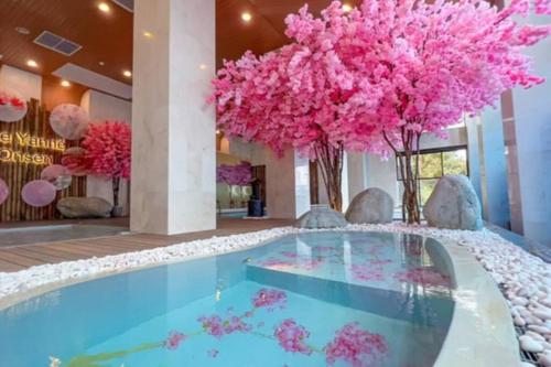 云顶高原Genting Peak 3PaxStudio412 @Ion Delemen的酒店大堂的游泳池,有粉红色的花朵