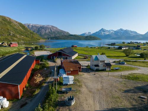 KvaløyaStorjord Farmstay Ranchhouse的享有湖泊和山脉农场的空中景致