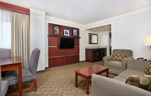 博林格林大学广场保龄格林假日酒店的一间客厅,客厅配有沙发和电视,位于酒店的房间